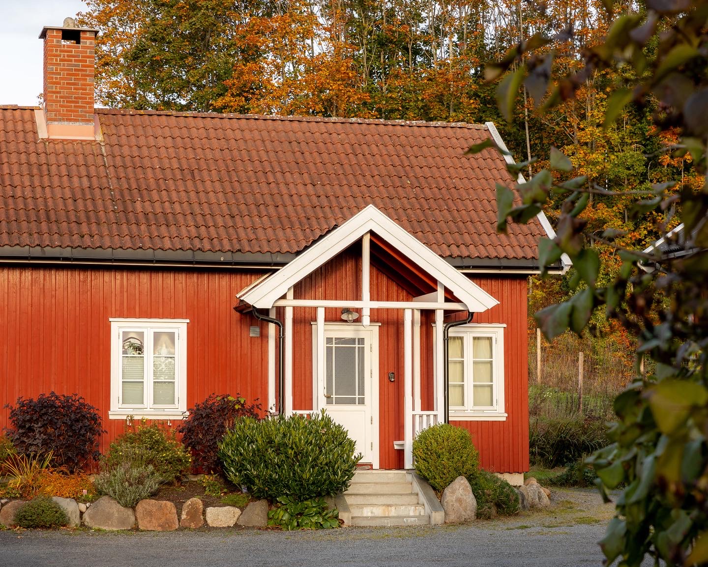 Bryggerhuset om høsten med blomsterbed foran