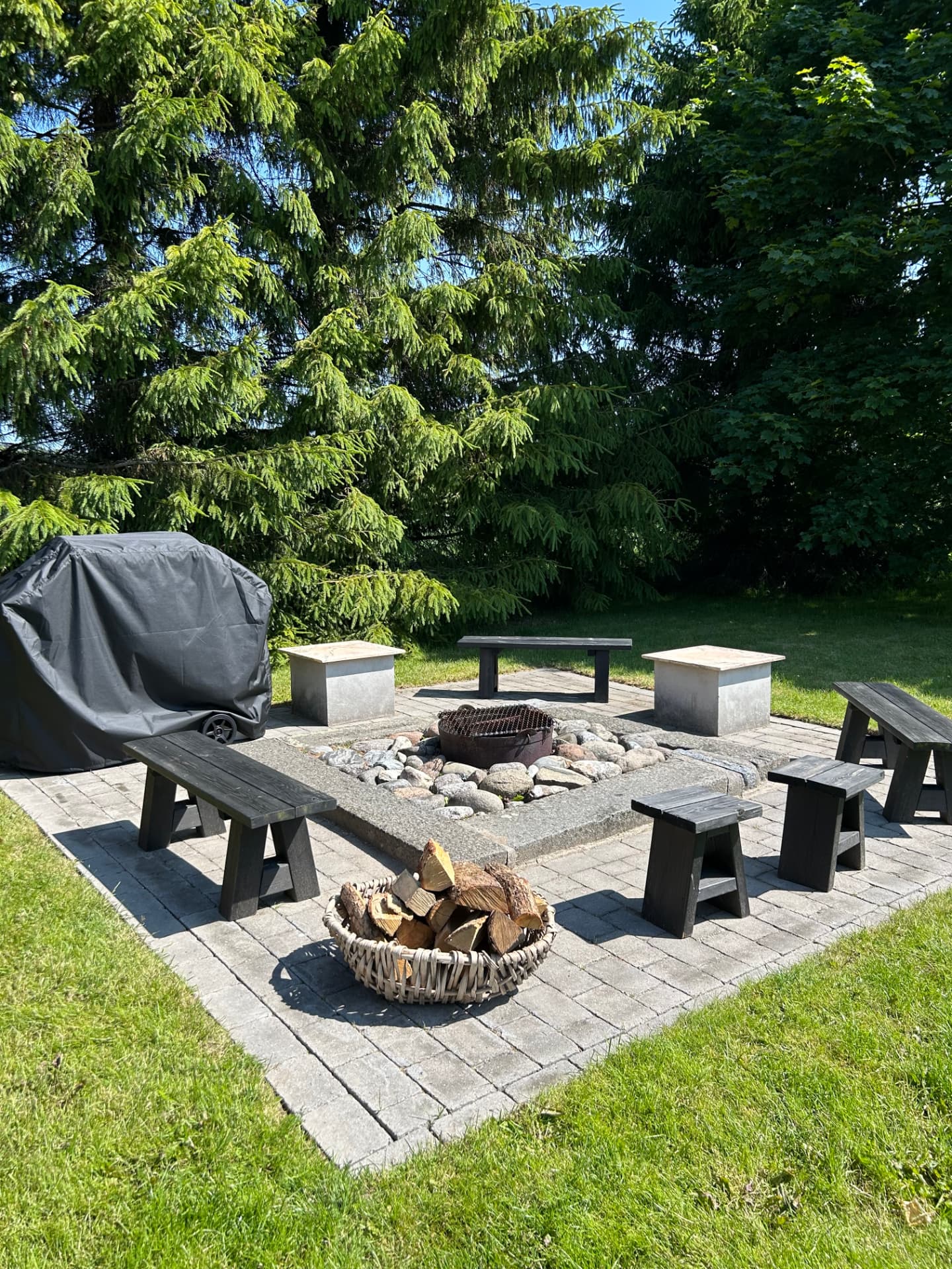 The fire pit with benches and a log basket