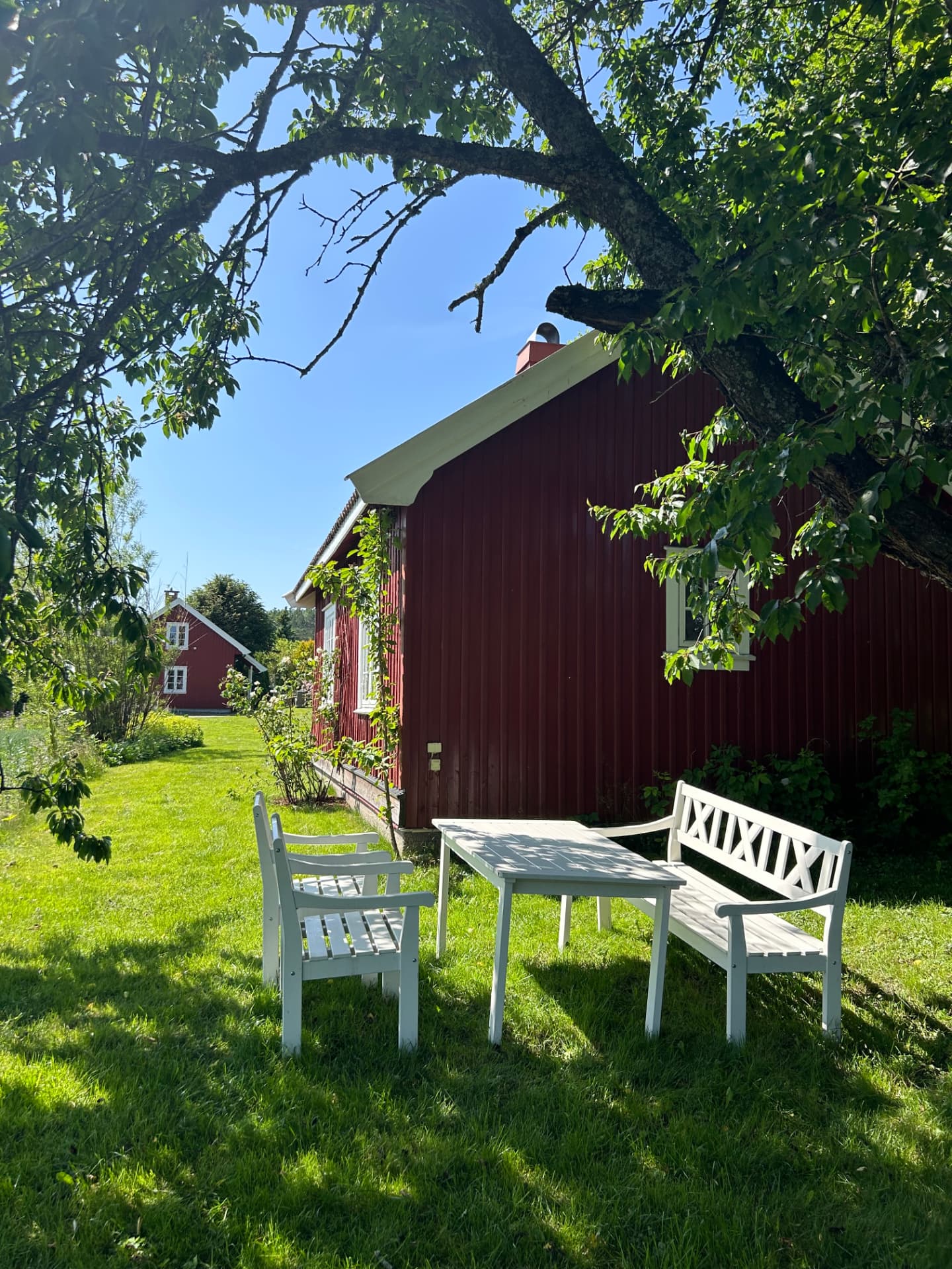 White garden seating by the red house