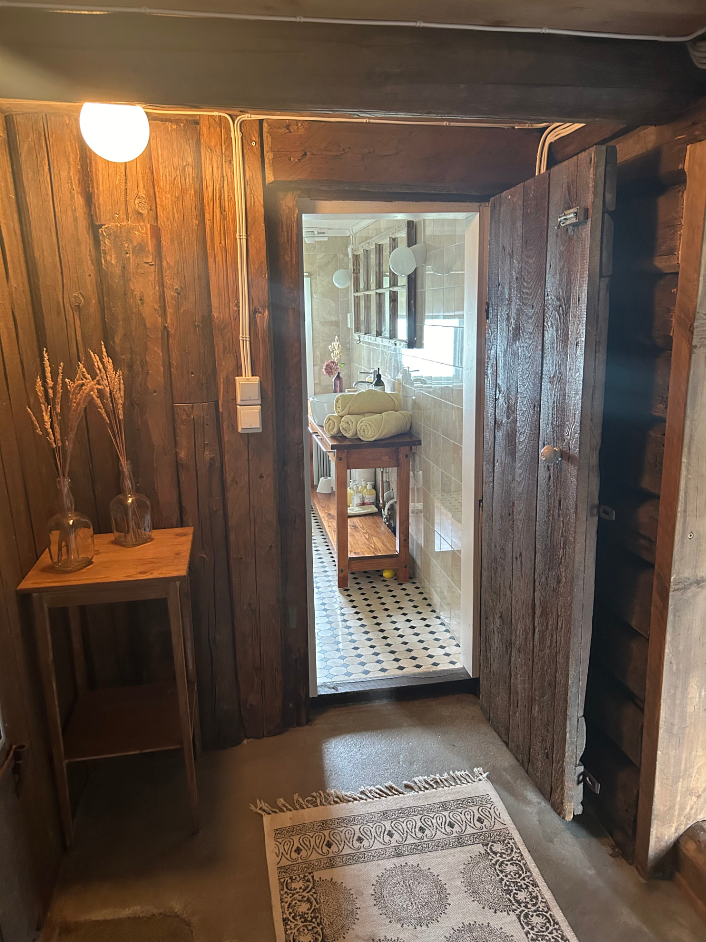 Hallway with log walls towards the bathroom