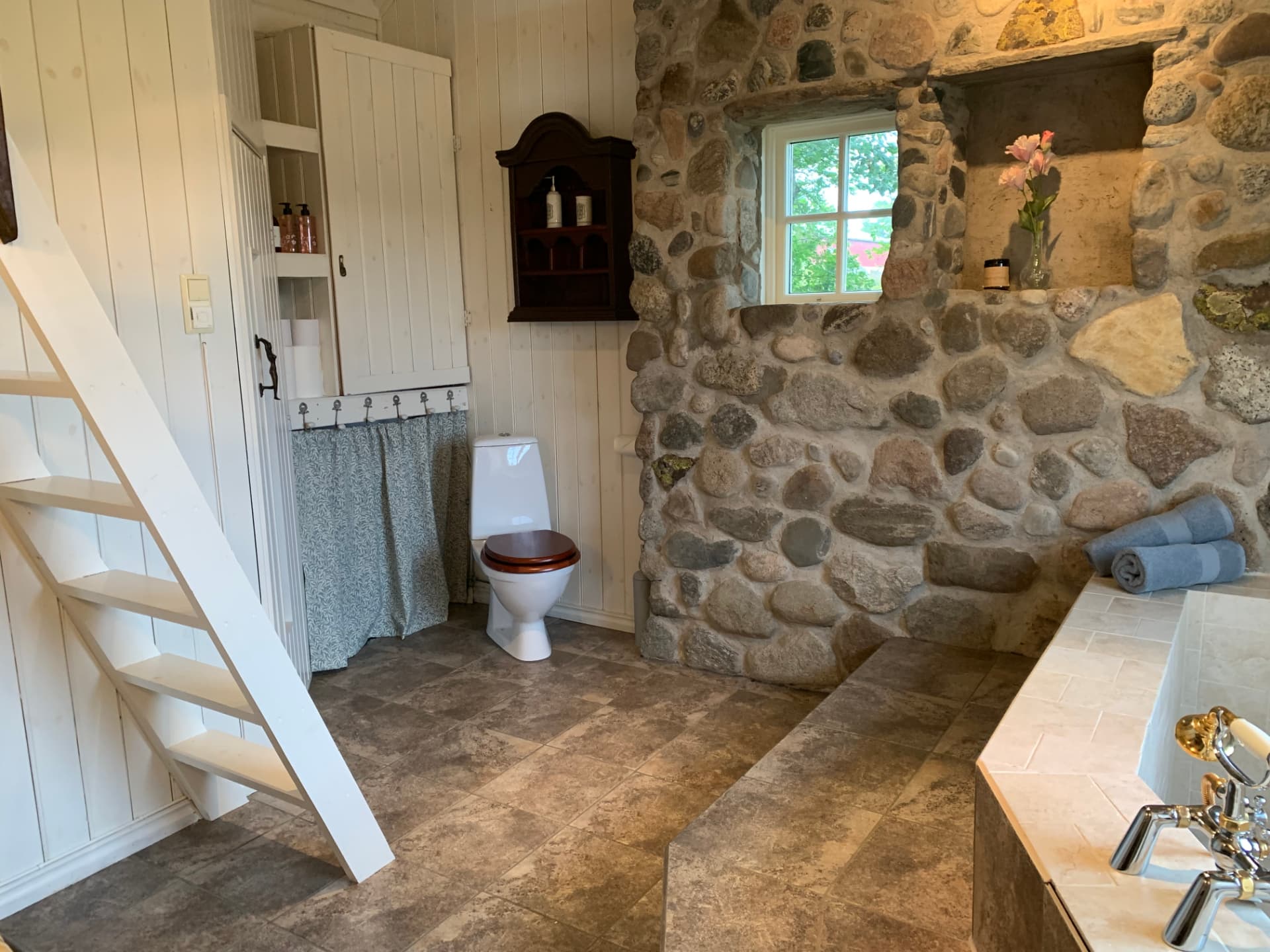 Bathroom with stone wall and stairs to the loft
