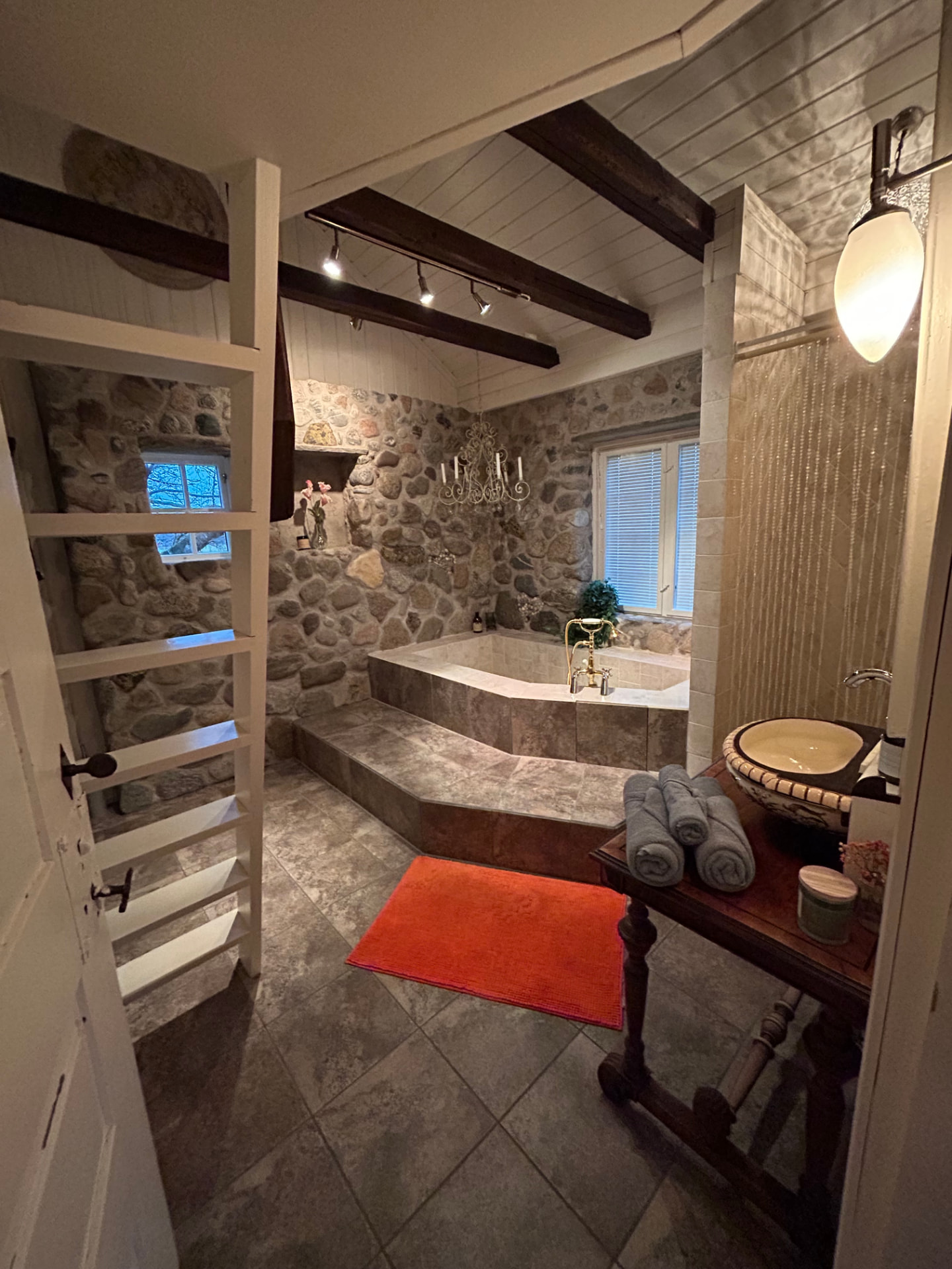 Bathroom with stone wall and Roman bathtub